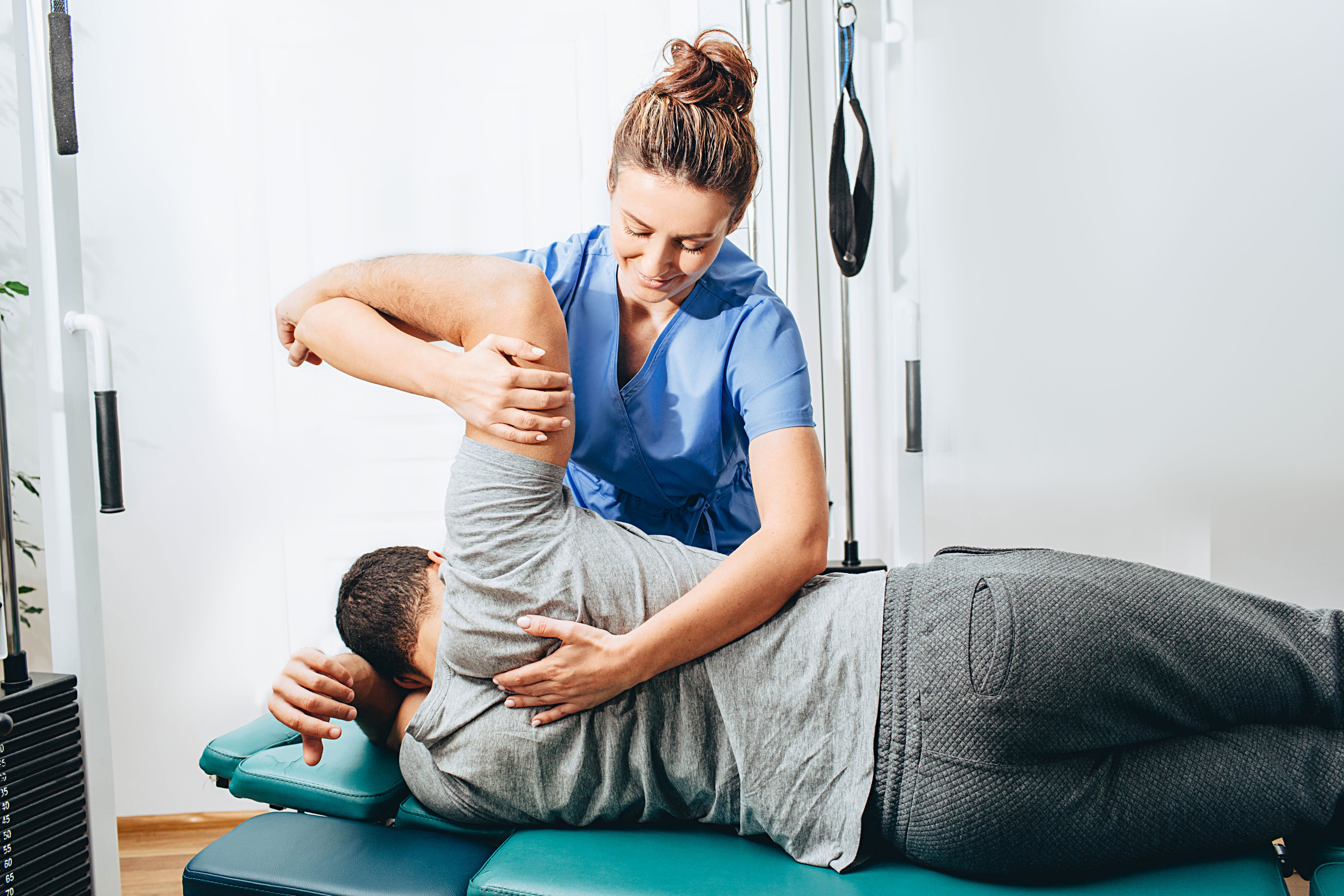 Physiotherapist treatment patient. She holding patient's hand, shoulder joint treatment Physiotherapist treatment patient. She holding patient's hand, shoulder joint treatment